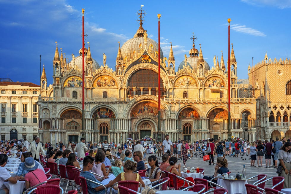 Basilica San Marco reflected in acqua alta in Piazza San Marco at twilight during sunset