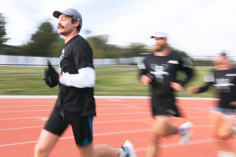 a man running on a track with a blurry background