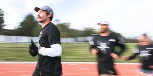 a man running on a track with a blurry background
