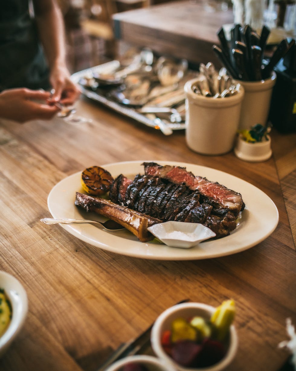 porción de carne a la parrilla con guarniciones en una mesa de comedor