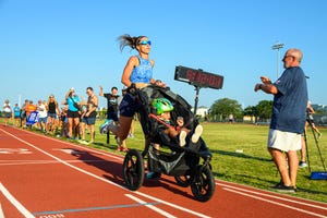 woman pushing stroller on a track