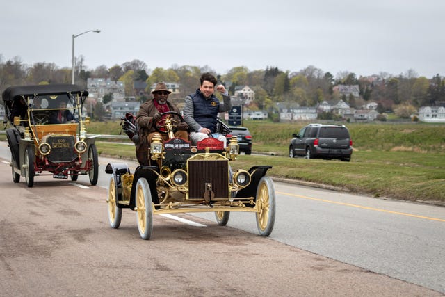 a group of people riding on an old car