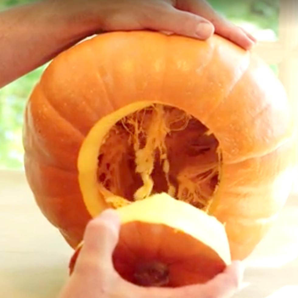 pumpkin carving, hand pulling the lid off a pumpkin