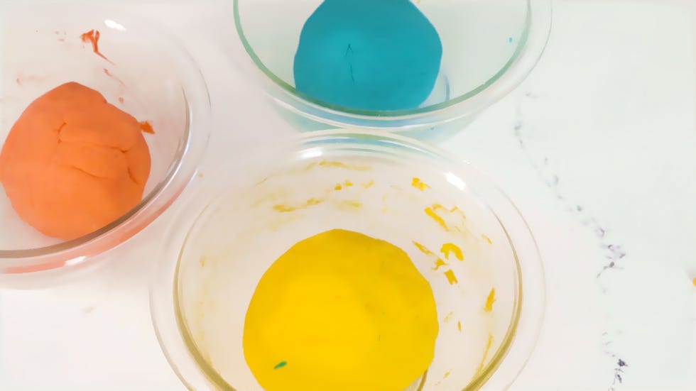 two bowls of homemade modeling dough in different colors