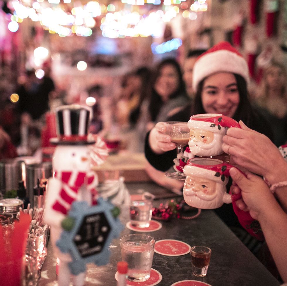 a group of people holding cups with christmas decorations