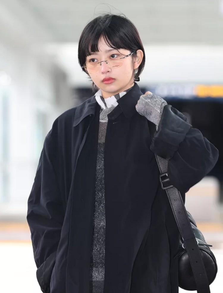 a person wearing a black coat and glasses