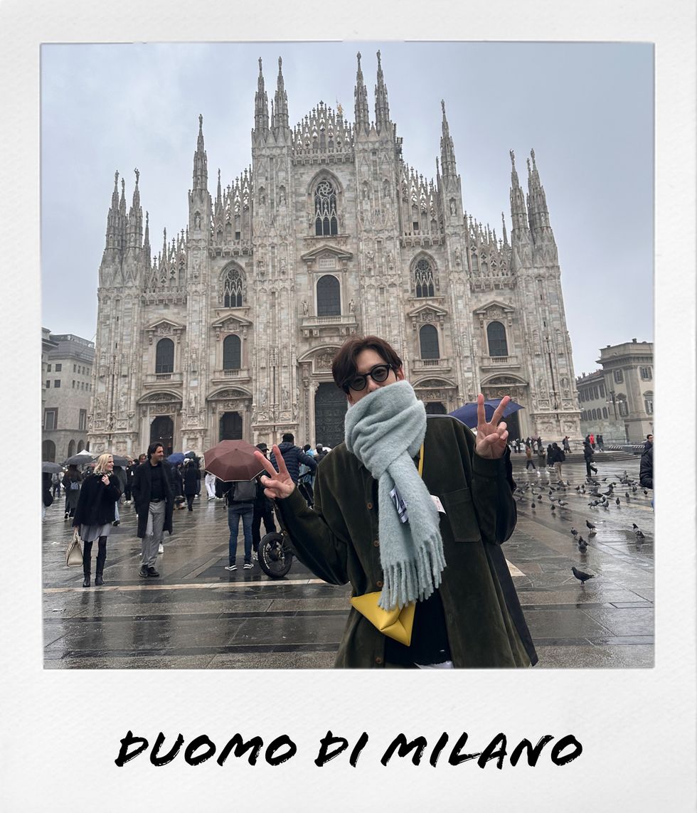 a person posing in front of milan cathedral with a large tower