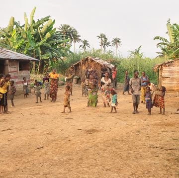 a group of people walking around a village