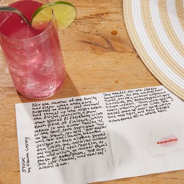 a glass of pink liquid and a note on a table