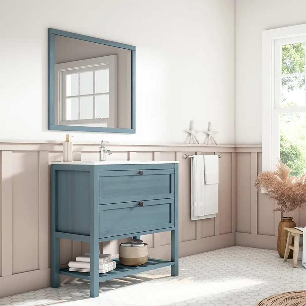un aseo con mueble lavabo en color azul, a juego con espejo