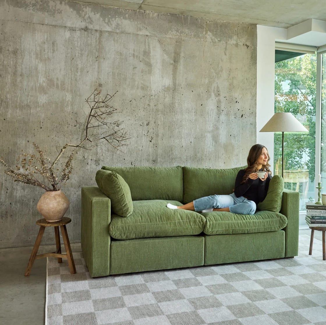 a cozy living room with a green sofa and a view of nature a cozy living room with a green sofa and a view of nature