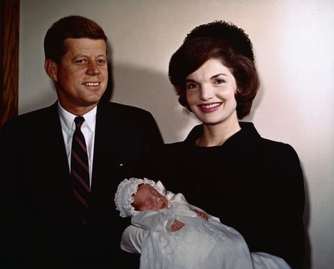 President John F. Kennedy with wife Jackie who is holding their son, John Jr., during his christening.