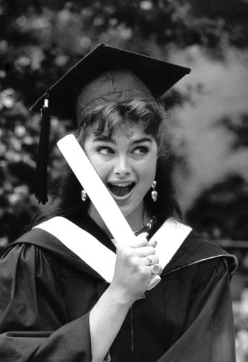 a person holding a graduation cap and gown