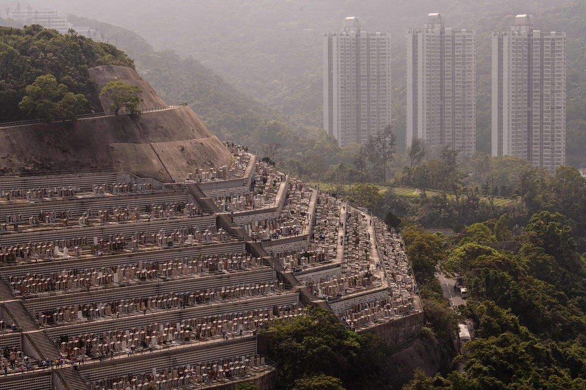 HONG KONG CEMETERY HONGKONG  In de wijk met de ietwat griezelige naam Happy Valley hebben niet alleen de levenden een adembenemend uitzicht In Happy Valley bevinden zich maar liefst acht kerkhoven Een daarvan is Hong Kong Cemetery waar de compacte graven op terrassen liggen langs een berghelling als een weerspiegeling van de opeengepakte wolkenkrabbers in de buurt