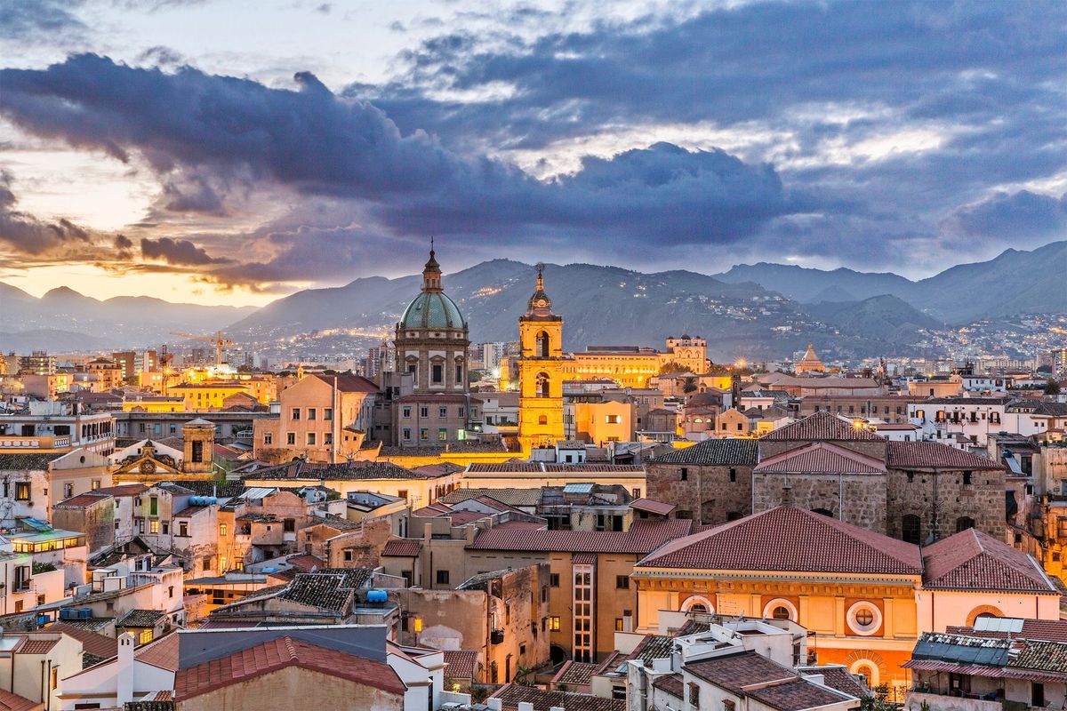De avond valt over Palermo en de klokkentoren van de 12deeeuwse Cattedrale della Santa Vergine Maria Assunta licht goud op