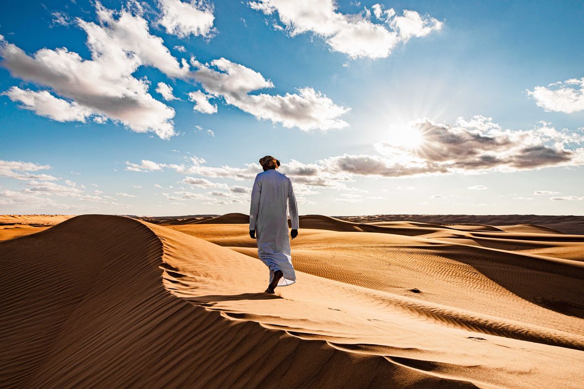 Al meteen toen we in Oman de woestijn inreden zag ik het licht en de uitgestrektheid van het landschap Vanaf een hoge zandduin met op de voorgrond een Omani kon ik dit goed vastleggen