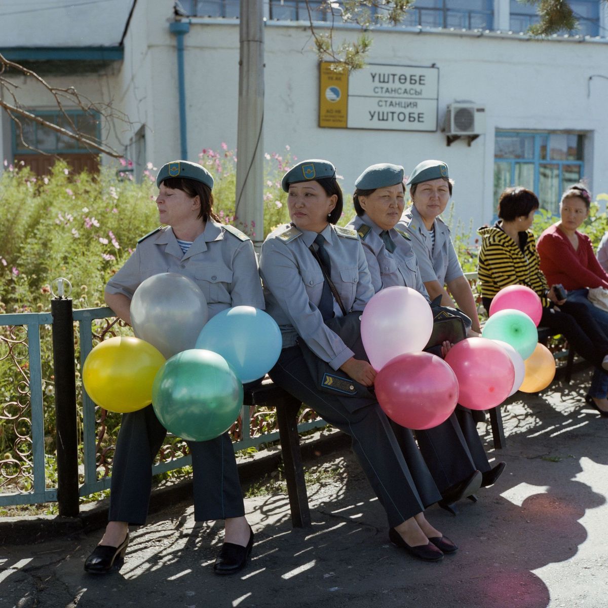 Vrouwelijke soldaten bekijken een militaire parade op een treinstation in het Kazachse Oesjtobe