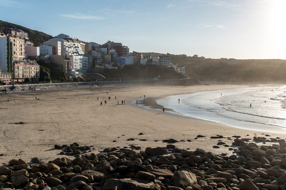 a beach with buildings and people
