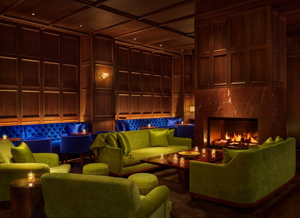 a living room with green couches and a fireplace