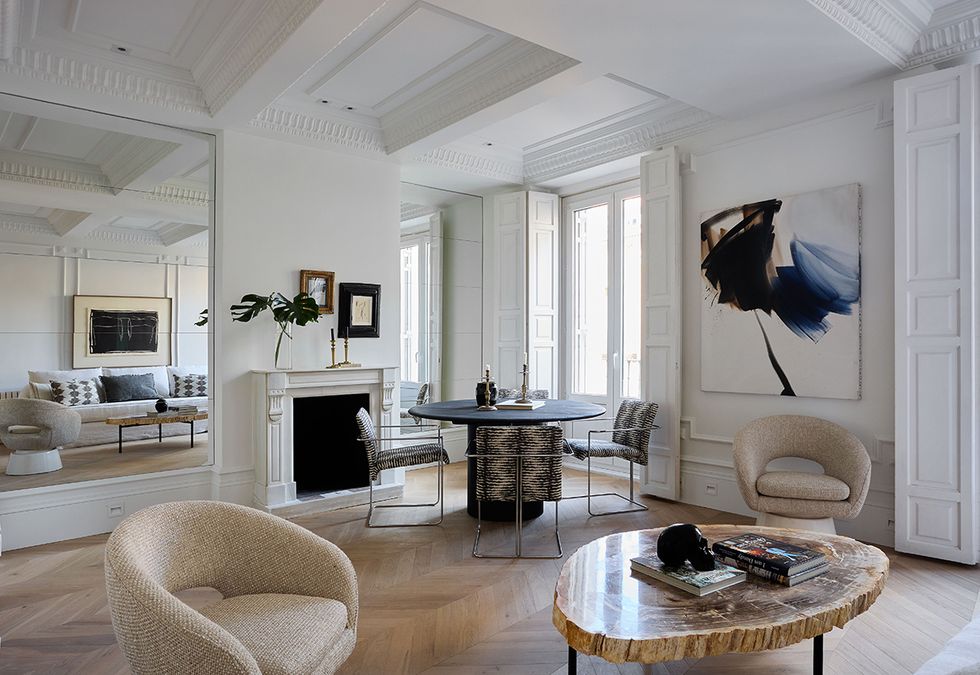 un salon clasico con chimenea de marmol y paredes de espejo