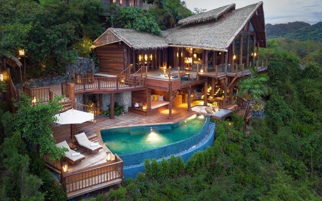 tropical villa with a pool surrounded by greenery
