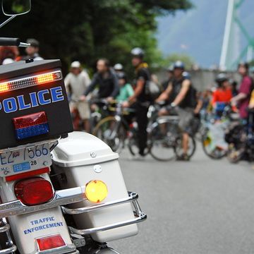 A police scooter in front of cyclists.