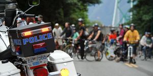 A police scooter in front of cyclists.