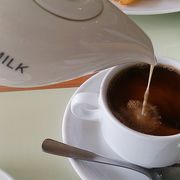 pouring milk into coffee