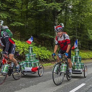 cyclists biking while carrying beer kegs