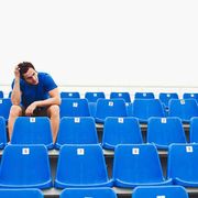 man sitting in empty bleachers procrastinating workout
