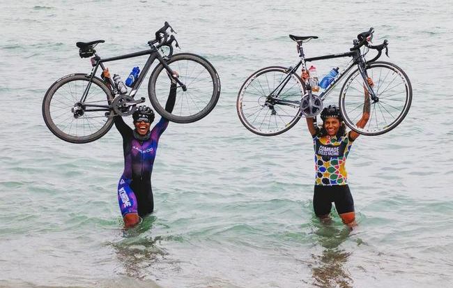 Ayesha McGowan and Friend with bikes overhead in the water