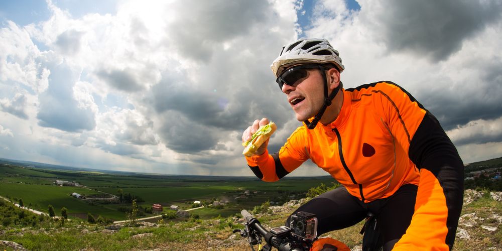 A cyclist eating healthier fast food options on a bike.
