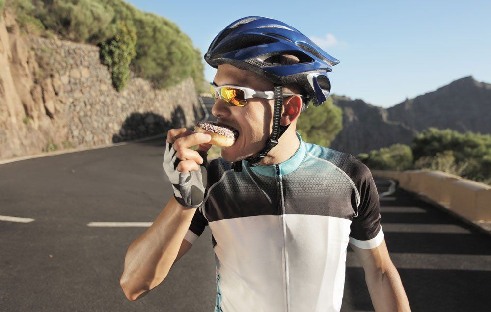 cyclist eating a doughnut