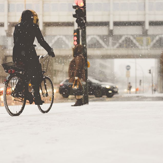 woman cycling in snowy city