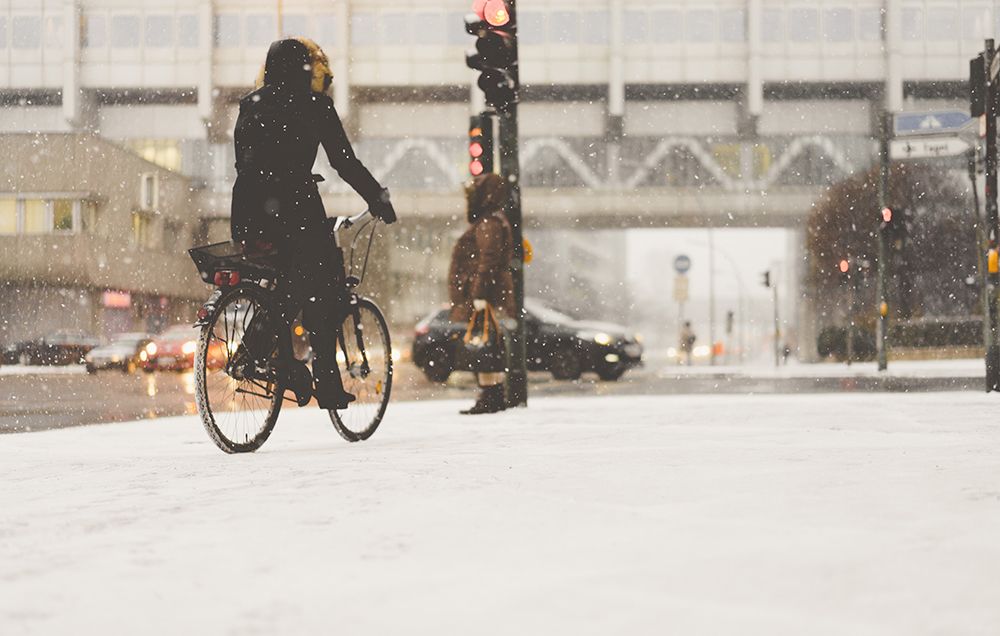 woman cycling in snowy city