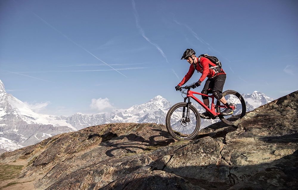 Rider on DT Swiss XRC 1200 Spline 25 wheels riding on boulders with mountains in the background