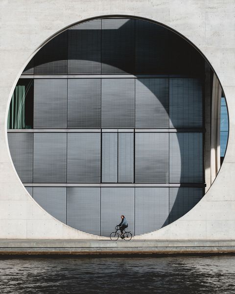 Een fietser passeert de achterkant van het Bundeskanzleramtin Berlijn De moderne architectuur van het gebouw bevat onder meer grote glazen wanden die de transparantie van de overheid moeten benadrukken