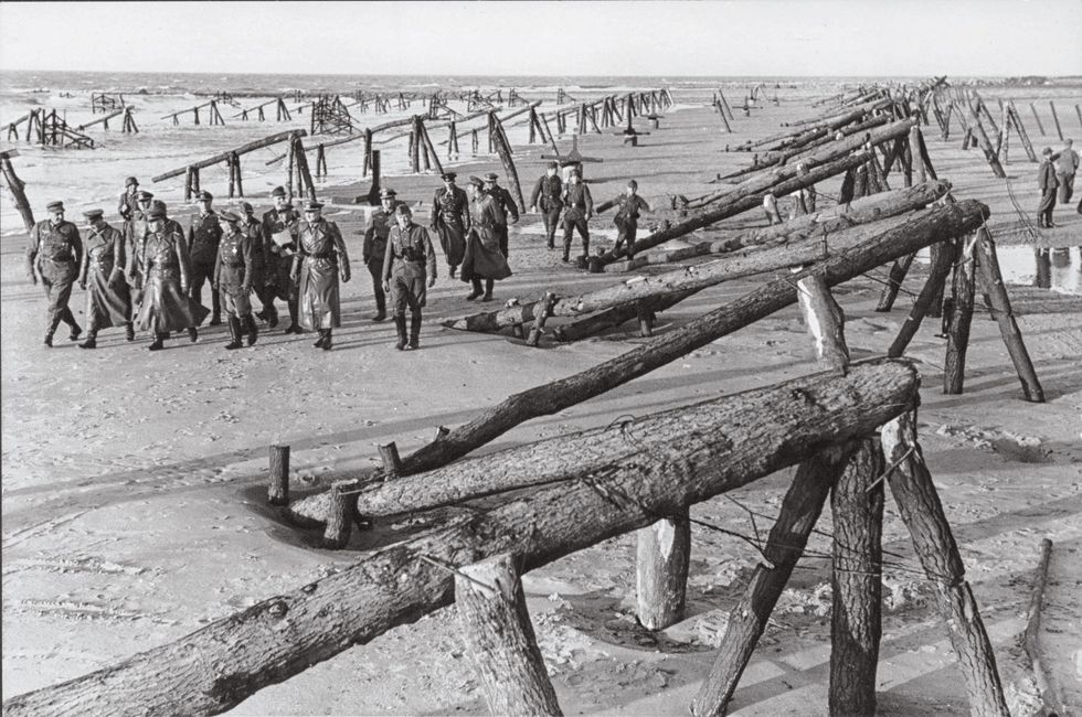 Rommel voorste rij derde van links inspecteert in april 1944 een strand bij Calais Hij gaf bevel om de obstakels die daar waren opgeworpen ook op de stranden van Normandi aan te leggen Zijn verzoek om de Normandische kust met meerdere pantserdivisies te verdedigen om een eventuele invasie het hoofd te bieden werd afgewezen
