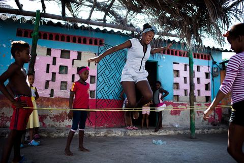Een groepje meisjes speelt Jimmy een traditioneel spel waarbij over een steeds hoger touw moet worden gesprongen