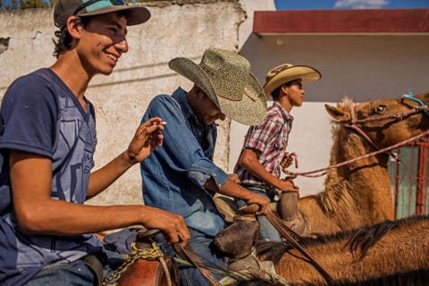 Een groep jongens rijdt op hun paarden mee in de processie van de cabalgata