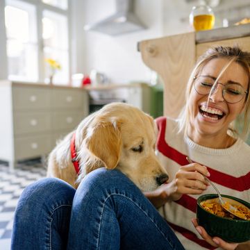 vrouw eet een gezond ontbijtje met een hond