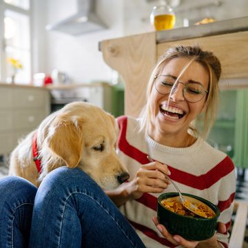 vrouw eet een gezond ontbijtje met een hond