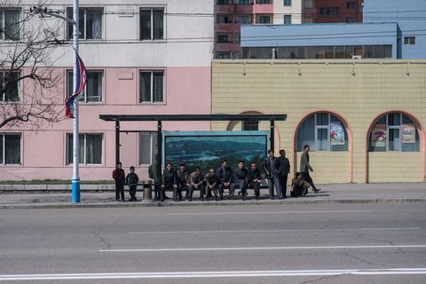 Op een foto die op zondag 9 april 2017 werd genomen wachten passagiers bij een bushalte in Pyongyang