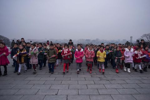 Kinderen leggen bloemen bij de standbeelden van de leiders Hoewel 16 februari wordt gevierd als de verjaardag van Kim Jong Il is zijn feitelijke geboortedatum onbekend