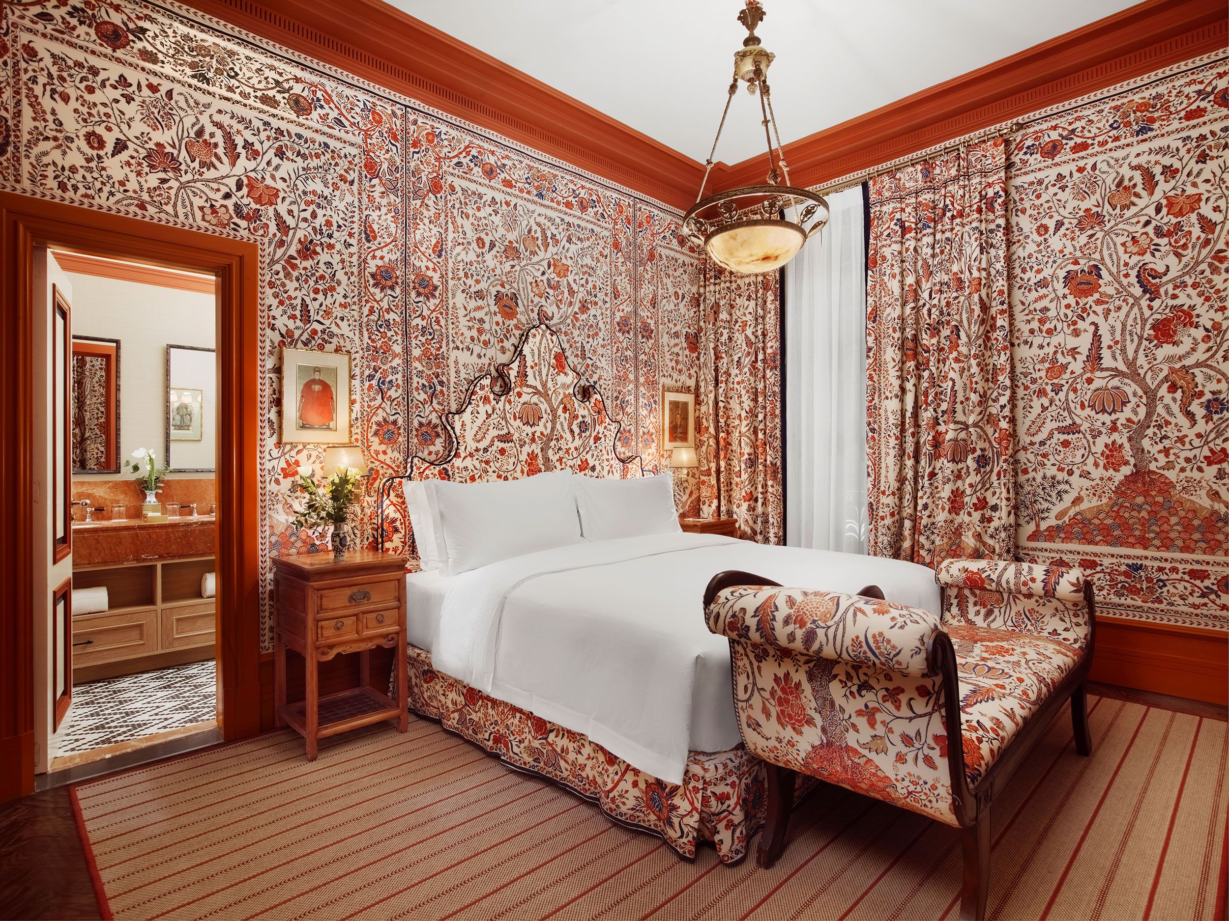 A List 2022 - ELLE DECOR upholstered bedroom with matching wallpaper and settee at foot of bed