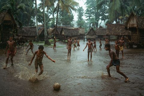 Op het eiland Kiriwina het grootste van de gelijknamige eilandengroep bij PapoeaNieuwGuinea spelen jongens voetbal in een ondergelopen dorp