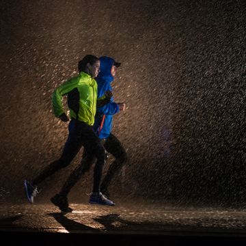 twee hardlopers lopen in het donker en regen