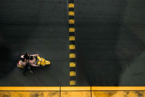 Op straat in Ho Chi MinhStad rijden drie vrouwen op n scooter