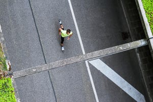 man hardlopen auto straat alleen foto van boven genomen