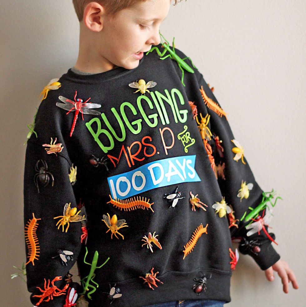 a boy wears a shirt with 100 fake insects on it and the slogan bugging mrs p for 100 days to celebrate the 100th day of school